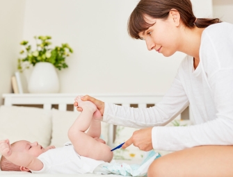 Femme prenant la température rectale d'un bébé